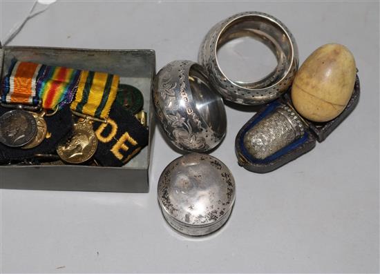 A WWI miniature group, small silver ivory egg, three silver napkin rings and a cased thimble.